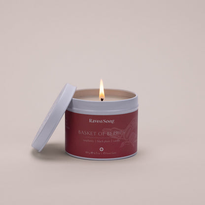 Candle in a red container labeled 'Raven Song Basket of Berries' 