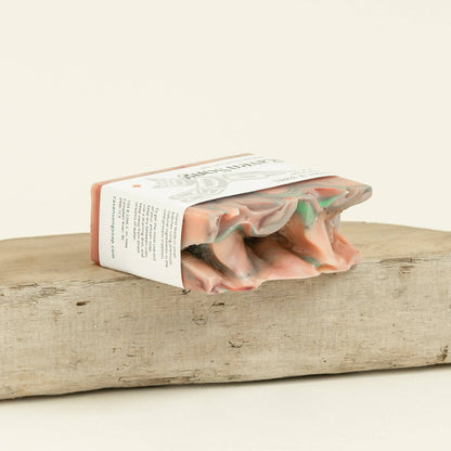 Pink and green soap bar on a wooden block