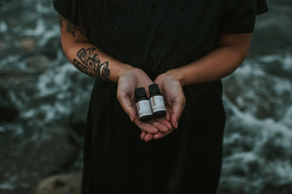 Person holding three small bottles in their hands with a blurred natural background