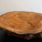 Wooden bowl with natural edge on a black surface