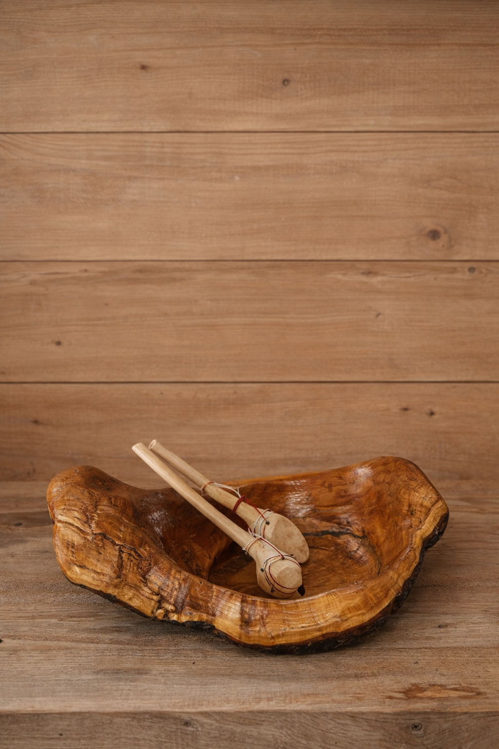 Wooden bowl and sticks on a wooden surface