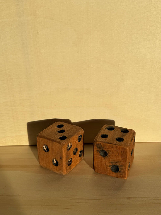 Two wooden dice on a wooden surface with a beige background
