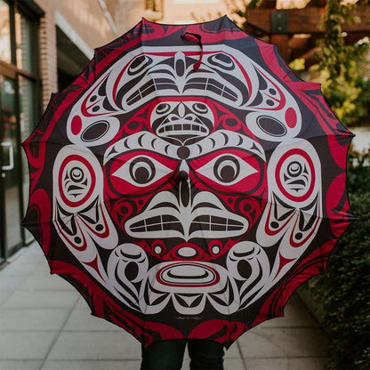 Pacific Umbrella Thunder Moon by Indigenous Artist Joe Wilson-Sxwaset displayed to its full size showcasing the artwork. A person is showing it to camera. They are standing on a sidewalk in front a building