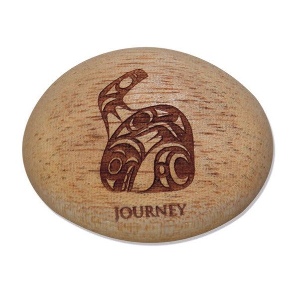 Photo of Indigenous Artwork of a whale by Maynard Johnny Jr. carved into a small rock wth the words 
Journey" engraved at the bottom. The pebble/ stone is displayed in front of a white background