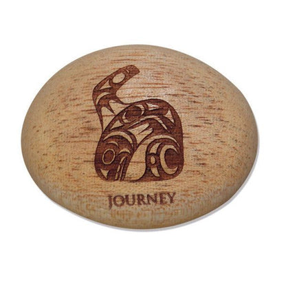 Photo of Indigenous Artwork of a whale by Maynard Johnny Jr. carved into a small rock wth the words 
Journey" engraved at the bottom. The pebble/ stone is displayed in front of a white background