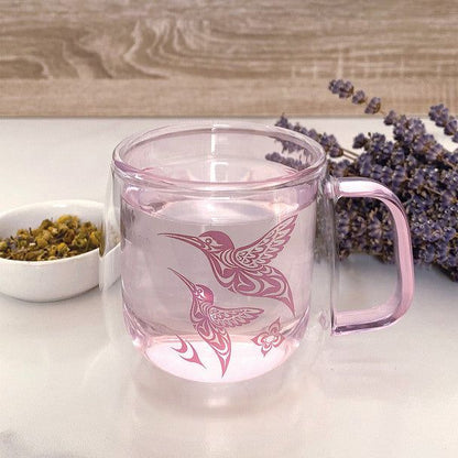 Double walled Glass Mug with Indigenous Design Hummingbird By Simone Diamond sitting on a counter with lavender beside it