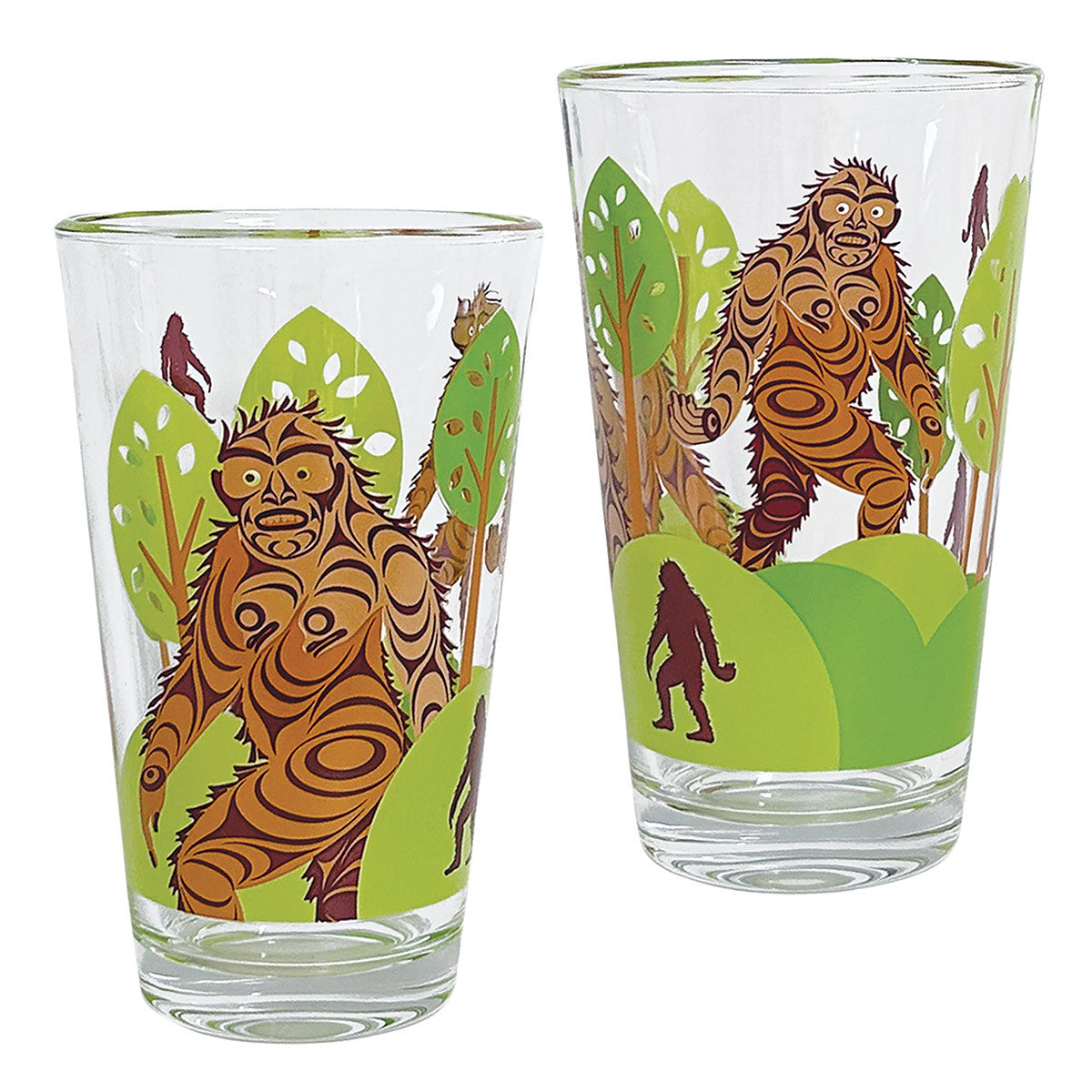 Set of two printed glass tumblers with a brown Sasquatch design among green trees by Francis Horne Sr.