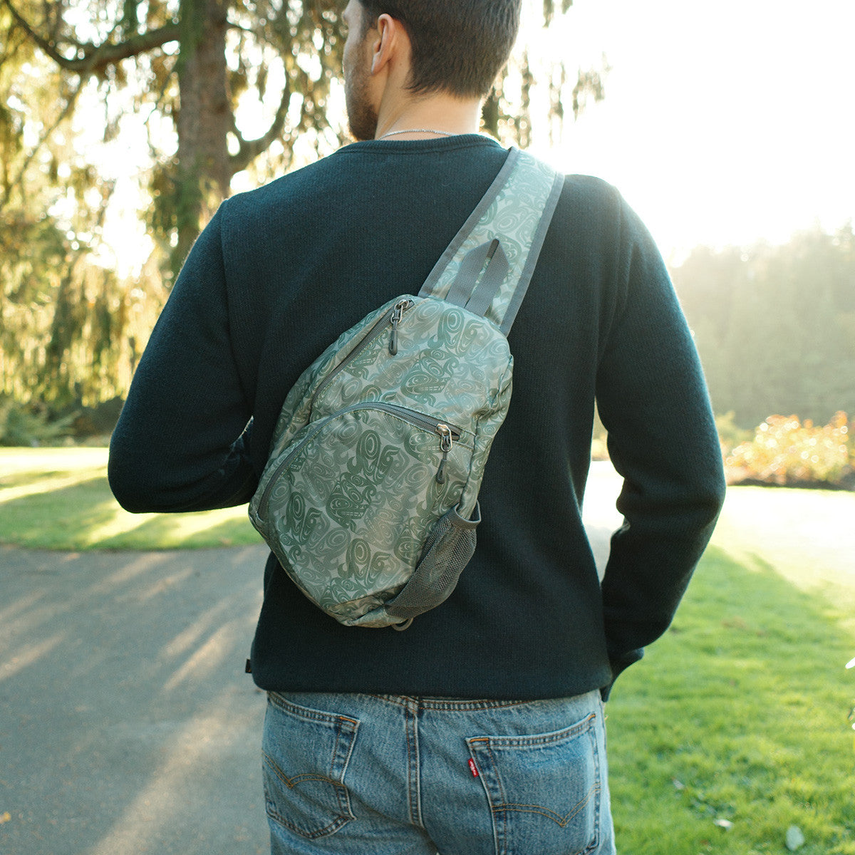 Person wearing the Urban Wolf sling pack across their back outdoors
