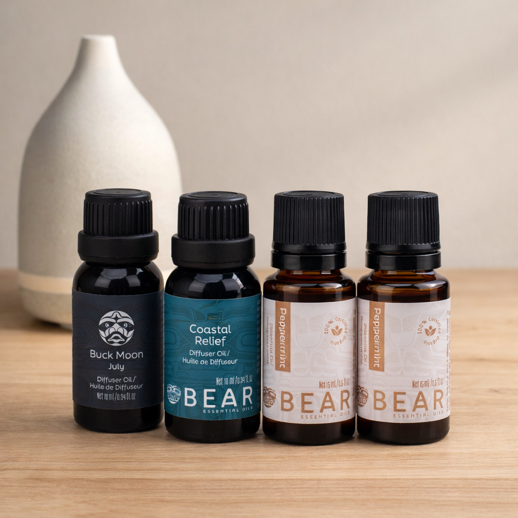 Four essential oil bottles with labels on a wooden surface.