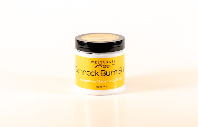 Sweetgrass Soap Bannock Bum Bum body butter in a clear jar with a black lid and yellow label, 118 ml.