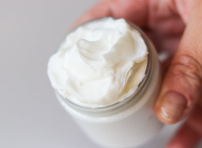 Whipped Sweetgrass Soap body butter swirled in an open jar, held in hand.