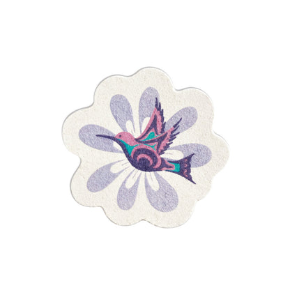 Flower-shaped eco sponge with a pink, purple and teal hummingbird over a lavender flower, designed by Nicole La Rock, on a natural sponge