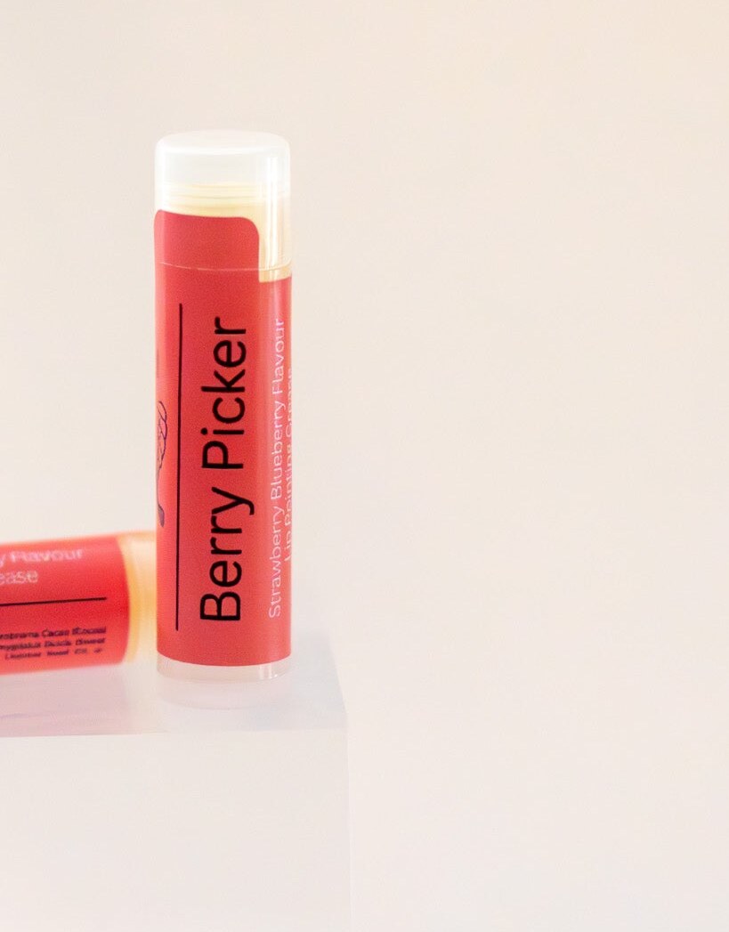 Berry Picker lip balm tube standing upright, coral label, strawberry blueberry flavour.
