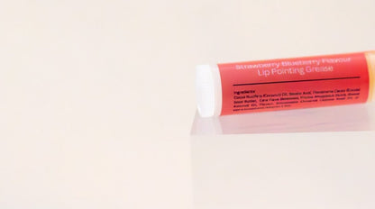 Berry Picker lip balm tube on its side showing the ingredient panel.