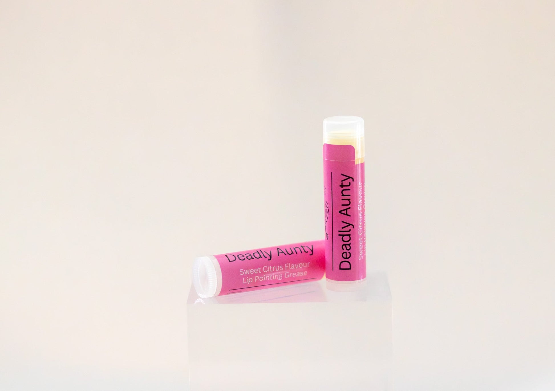 Sweetgrass Soap Deadly Aunty lip balm twist-up tube with a pink label, two shown.
