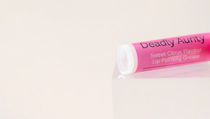 Deadly Aunty lip balm tube on its side showing the ingredient panel.