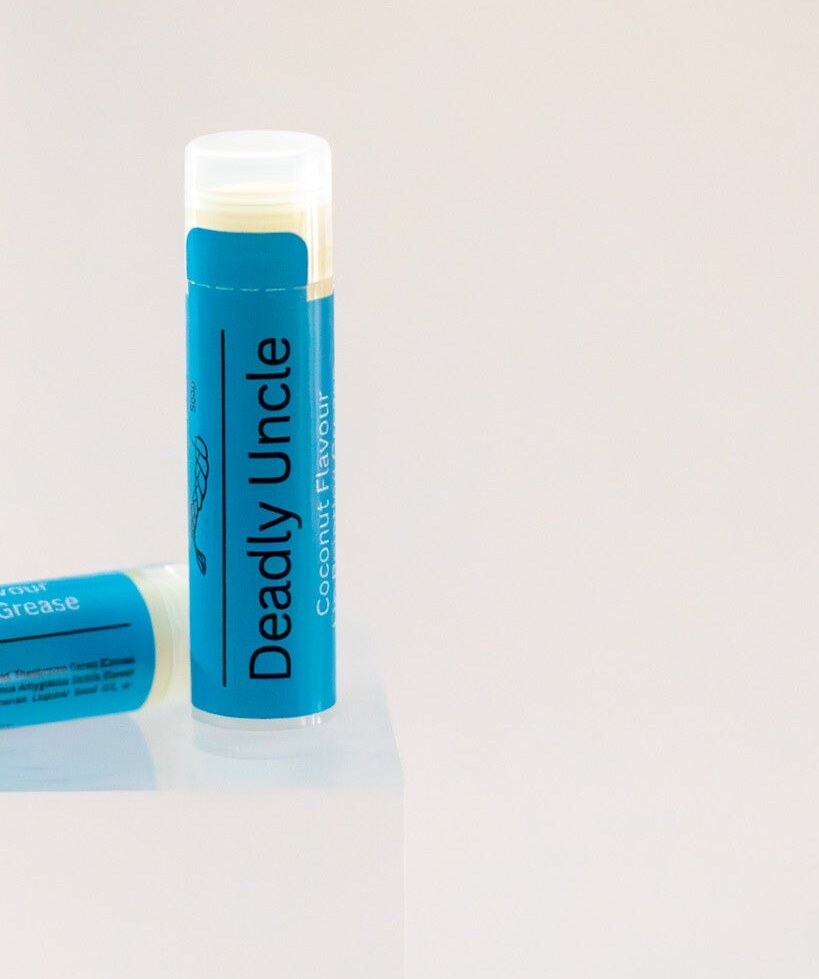 Deadly Uncle lip balm tube standing upright, blue label, coconut flavour.
