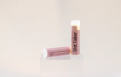 Sweetgrass Soap Sh*t Talker lip balm twist-up tube with a dusty pink watermelon label, two shown.