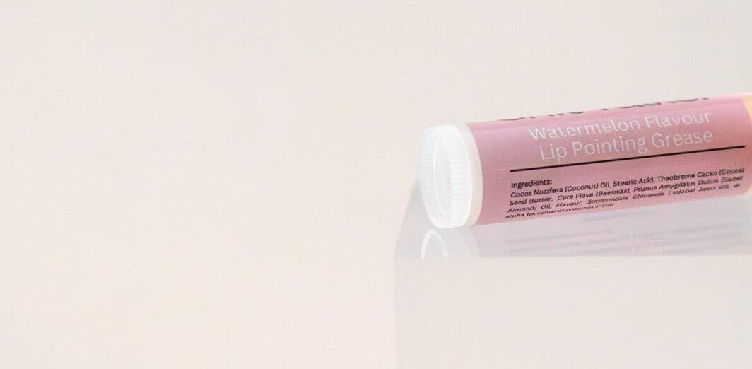Sh*t Talker lip balm tube on its side showing the ingredient panel.