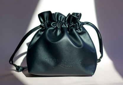 Sweetgrass Soap black vegan-leather drawstring toiletry bag with an embossed logo.