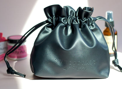 Black drawstring toiletry bag styled with Sweetgrass Soap body butter and smudge spray.
