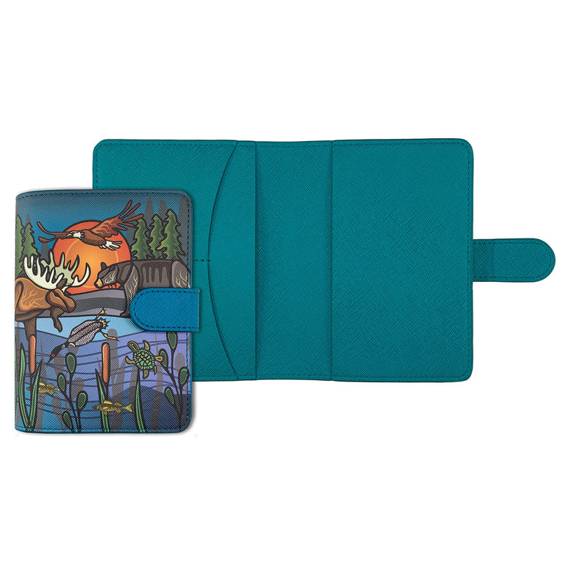 All My Relatives passport holder in teal vegan leather, designed by Storm Angeconeb, showing a moose, eagle, raccoon, loon, turtle and fish among cattails under an orange sun