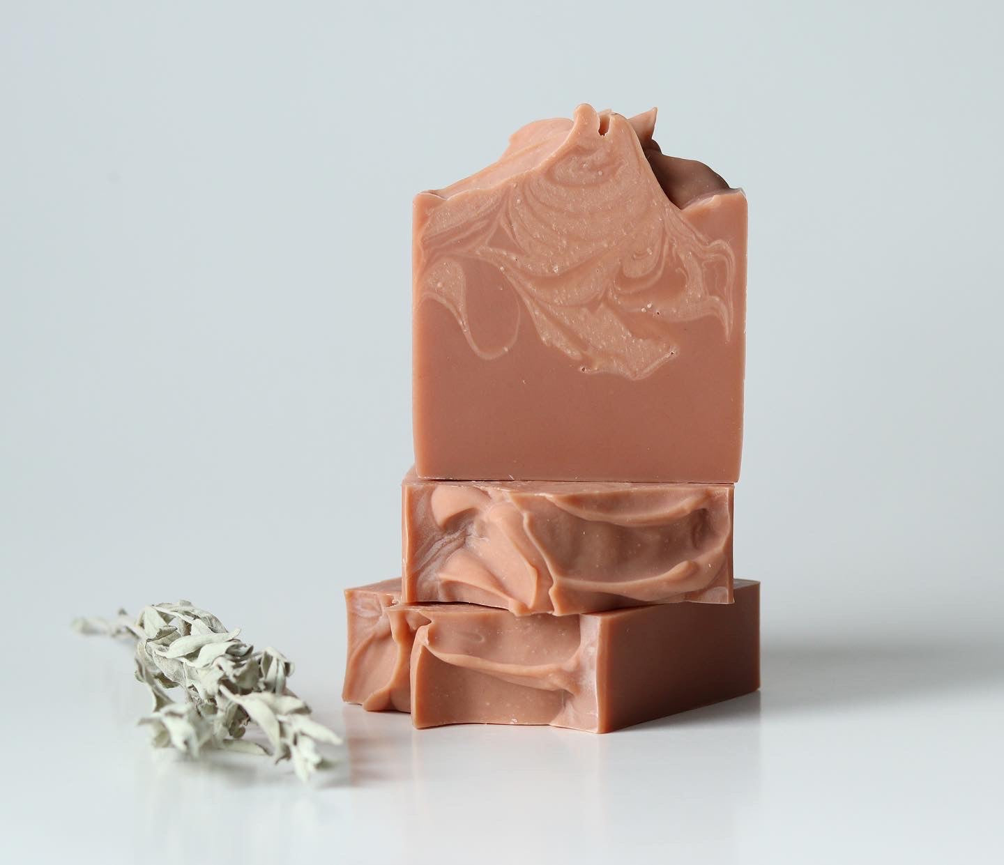 Sweetgrass Soap Smudge Soap, three stacked terracotta clay bars with a dried sage sprig.