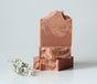 Sweetgrass Soap Smudge Soap, three stacked terracotta clay bars with a dried sage sprig.