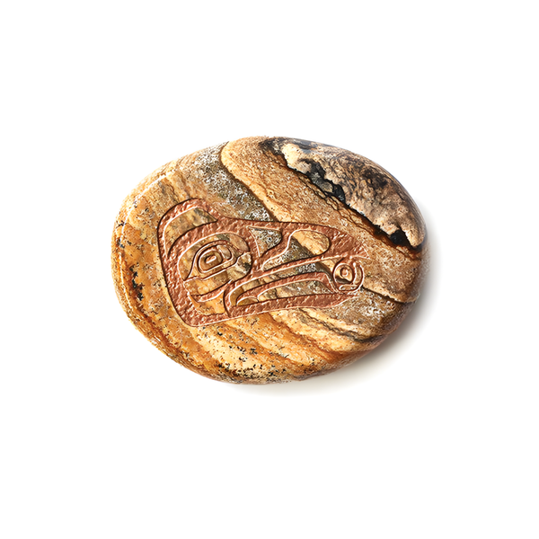 Round jasper stone with Indigenous raven design etched into it