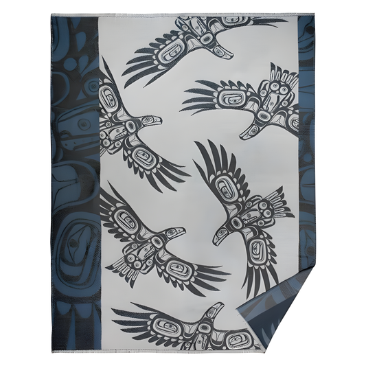 Grey woven decorative blanket with dark blue trim and Indigenous soaring eagle design