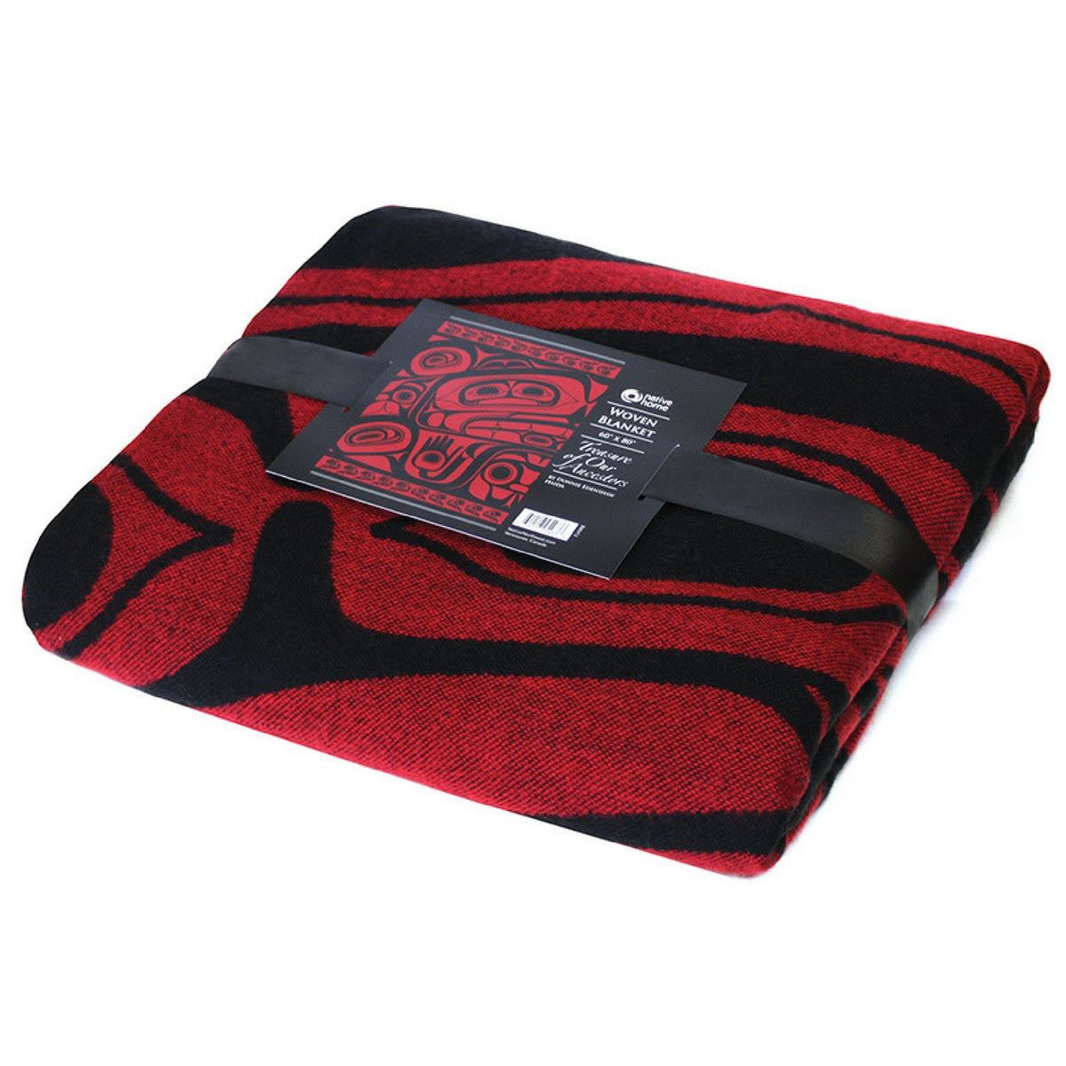 Treasure of Our Ancestors woven blanket folded with packaging ribbon and artist card on a white background